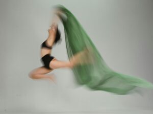 blurry photo of a dancer holding green chiffon