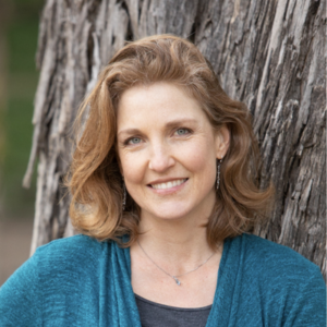 Portrait of Brooke Ray Demko, Director of Public Realm, standing outdoors in front of a tree.